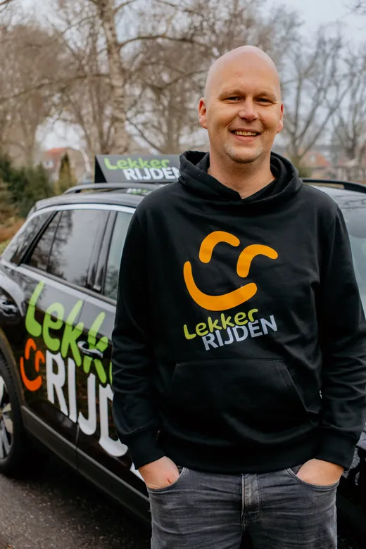 Jurgen Palland, rij-instructeur en oprichter van Lekker Rijden, voor zijn lesauto in Tuk